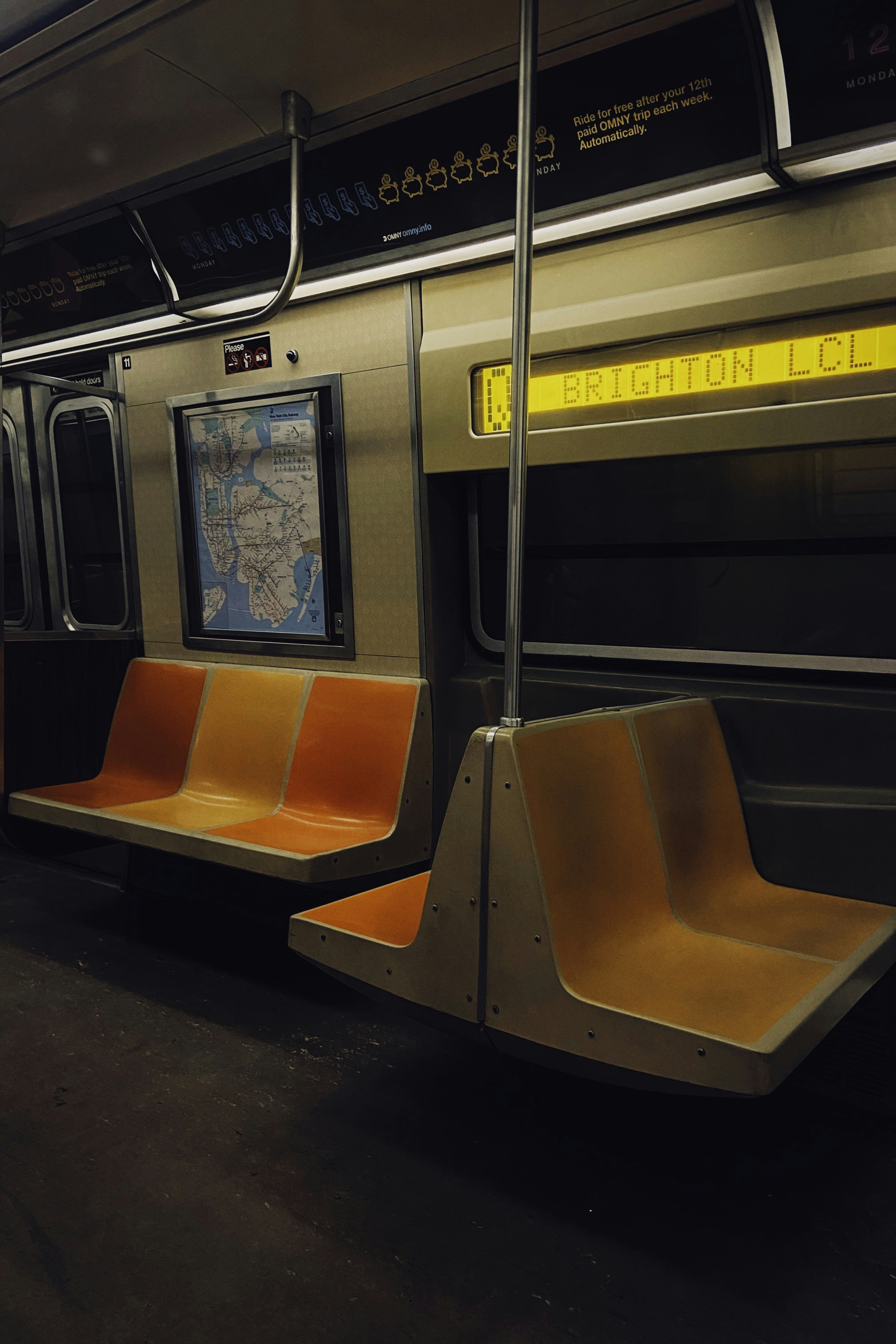 A quiet subway carriage with amber seats and dim evening light.
